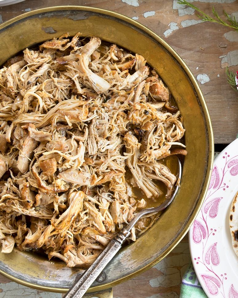 beer braised shredded chicken in a gold serving dish with a spoon