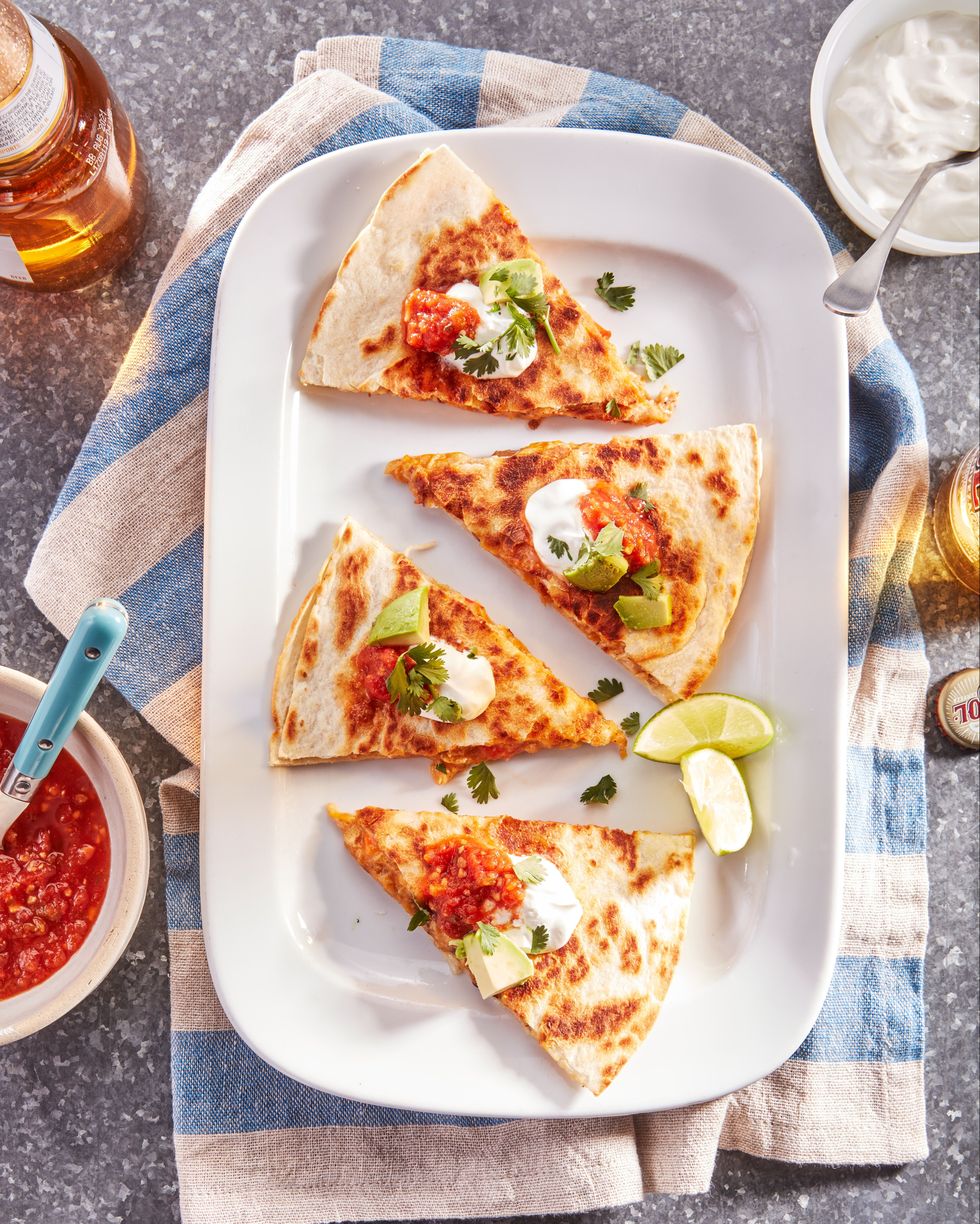chicken quesadillas cut into triangles and arranged on a white rectangular plate